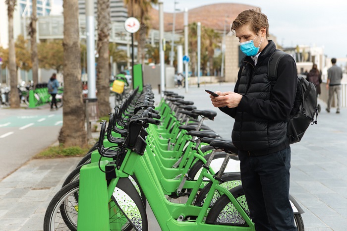 Young,Man,Unlocks,Bicycle,With,His,Mobile,Phone.,Electric,Bicycle