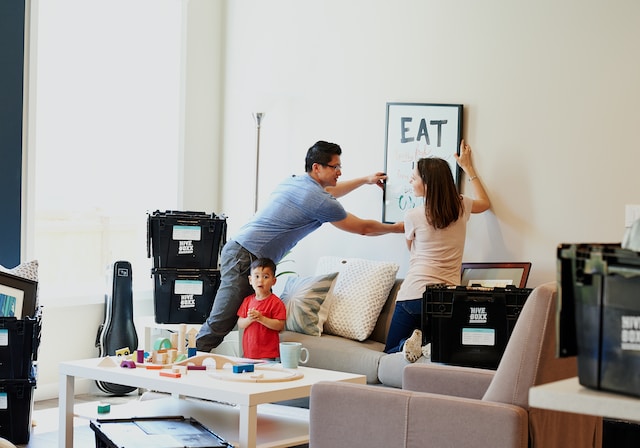 A family of three unpacking after moving into their new home.